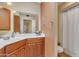 Bathroom with corner vanity, wood cabinets, and a shower at 15825 N 110Th Ave, Sun City, AZ 85351