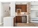 Wet bar with stone accent wall, wood cabinets, and mini-fridge at 1714 E Saltsage Dr, Phoenix, AZ 85048