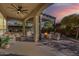 Spacious covered patio featuring an outdoor kitchen, comfortable seating, and a charming pergola-covered fire pit area at 189 E Atacama Ln, Queen Creek, AZ 85140