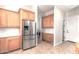 Kitchen with stainless steel refrigerator, light wood cabinets, and laundry access at 4213 E Edgemont Ave, Phoenix, AZ 85008