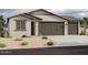 New single-story home with a three-car garage and desert landscaping at 4235 E Brook Lynn Pl, San Tan Valley, AZ 85143