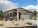 Single-story home with gray exterior, stone accents, and a two-car garage at 5624 W Summerside Rd, Laveen, AZ 85339