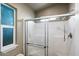 A bright bathroom featuring a glass-enclosed shower with window at 650 N Hawes Rd # 3510, Mesa, AZ 85207