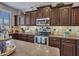 Well-equipped kitchen with dark wood cabinets, granite countertops, and stainless steel appliances at 6868 W Cottontail Ln, Peoria, AZ 85383