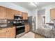 Well-lit kitchen featuring stainless steel appliances, granite countertops, and wooden cabinetry at 743 E Horizon Heights Dr, San Tan Valley, AZ 85143