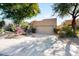 Tan stucco house with a two-car garage and nicely landscaped front yard at 8227 E Sierra Pinta Dr, Scottsdale, AZ 85255
