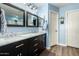 Bathroom with dual sinks, marble countertops, and blue walls at 8642 W Harmony Ln, Peoria, AZ 85382