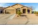 Single-story house with tan exterior, two-car garage, and desert landscaping at 8642 W Harmony Ln, Peoria, AZ 85382