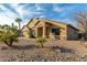 One-story home with a tan stucco exterior, palm trees, and gravel landscaping at 8642 W Harmony Ln, Peoria, AZ 85382