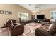 Living room with brown leather furniture and a large TV at 8642 W Harmony Ln, Peoria, AZ 85382