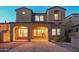 Beautiful two-story stucco house with a tile roof and covered patio, illuminated at twilight at 9305 E Canyon View Rd, Scottsdale, AZ 85255