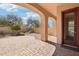 Covered patio with brick pavers overlooks a landscaped yard with desert trees and a privacy wall at 9305 E Canyon View Rd, Scottsdale, AZ 85255