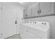 Laundry room with washer, dryer, and upper cabinets at 9544 W Sierra Pinta Dr, Peoria, AZ 85382