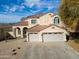 Charming two-story home with a three car garage and a well-maintained front yard on a sunny day at 126 E Key West Dr, Casa Grande, AZ 85122