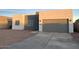 Modern stucco home with gray garage door and gravel driveway at 14825 S Charco Rd, Arizona City, AZ 85123