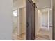 Bright hallway with barn door and wood floors at 14825 S Charco Rd, Arizona City, AZ 85123