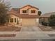 Two-story house with tan exterior, tile roof, and a two-car garage at 15877 W Diamond St, Goodyear, AZ 85338