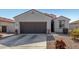 House exterior with a brown garage door and landscaping at 1673 E Jardin Pl, Casa Grande, AZ 85122