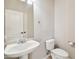 This half bathroom offers a white pedestal sink and matching toilet, plus an oval mirror and chrome hardware at 1801 W Nighthawk Way, Phoenix, AZ 85045