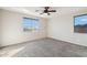 This empty bedroom features neutral walls, carpeted floors, dual windows, and an overhead ceiling fan with lighting at 1801 W Nighthawk Way, Phoenix, AZ 85045