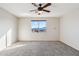 Empty bedroom displays neutral walls, carpeted floors, a window, an overhead ceiling fan and a closet at 1801 W Nighthawk Way, Phoenix, AZ 85045