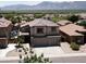 Two-story home featuring desert landscaping, a spacious driveway, and a two-car garage in a community setting with mountain views at 1801 W Nighthawk Way, Phoenix, AZ 85045