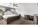 Main bedroom with large bed, ceiling fan, and ample dresser space at 18320 N Betty Ct, Maricopa, AZ 85138