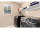 Laundry room with washer, dryer, and shelving at 18320 N Betty Ct, Maricopa, AZ 85138