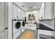 Well-organized laundry room with modern appliances, white cabinetry, and ample counter space at 18831 E Augusta Ave, Queen Creek, AZ 85142