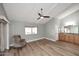 Bright bedroom with wood-look floors, ceiling fan, and access to bathroom at 2329 N Recker Rd # 23, Mesa, AZ 85215