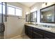 Double vanity bathroom with granite countertops and mirrors at 23610 S Desert Moon Ct, Sun Lakes, AZ 85248
