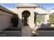 Inviting front entry with arched entryway and wrought iron door at 23610 S Desert Moon Ct, Sun Lakes, AZ 85248