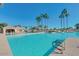 Community pool with a large deck and palm trees at 23610 S Desert Moon Ct, Sun Lakes, AZ 85248