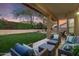 Spacious backyard with lush lawn, covered patio, and string lights at 26803 N 45Th Pl, Cave Creek, AZ 85331