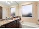 Bathroom boasts granite vanity, bathtub, and large window at 31048 N 56Th St, Cave Creek, AZ 85331
