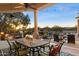 Covered patio with dining table and chairs, adjacent to a pool and waterfall at 31048 N 56Th St, Cave Creek, AZ 85331