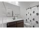 Clean bathroom with dark vanity, pineapple shower curtain, and mirror at 35208 W Santa Monica Ave, Maricopa, AZ 85138