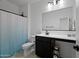 Modern bathroom with dark vanity, white toilet, and blue shower curtain at 35208 W Santa Monica Ave, Maricopa, AZ 85138
