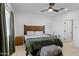 Bedroom with wood bed frame, ceiling fan, and ensuite bathroom access at 35208 W Santa Monica Ave, Maricopa, AZ 85138