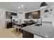 Modern kitchen with dark cabinetry, granite counters, and island at 35208 W Santa Monica Ave, Maricopa, AZ 85138