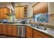 Kitchen with corner sink, granite countertops, and light wood cabinets at 5827 N 129Th Ave, Litchfield Park, AZ 85340