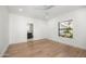Bright bedroom with wood floors and white walls leads to the bathroom and a view of the yard at 10041 N 52Nd Pl, Paradise Valley, AZ 85253