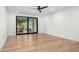 Spacious room with sleek ceiling fan, hardwood floors, large sliding glass door, and neutral paint at 10041 N 52Nd Pl, Paradise Valley, AZ 85253