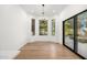 Bright dining area with hardwood floors, modern lighting, and large windows with black frames showcasing the outdoor space at 10041 N 52Nd Pl, Paradise Valley, AZ 85253