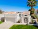 Stunning exterior of home features two-car garage, gated courtyard, and a palm tree at 10041 N 52Nd Pl, Paradise Valley, AZ 85253
