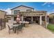 Back patio features travertine tile, a pergola, an outdoor kitchen, and a dining area at 3241 E Aris Dr, Gilbert, AZ 85298