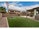 Spacious backyard boasts artificial turf, a fire pit, and a covered patio with an outdoor kitchen at 3241 E Aris Dr, Gilbert, AZ 85298