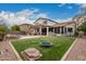 Expansive backyard featuring a lush lawn, covered patio, outdoor kitchen, and relaxing lounge area at 3241 E Aris Dr, Gilbert, AZ 85298
