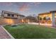 Expansive backyard features lush artificial turf, paver patio, outdoor kitchen, and cozy fire pit for entertaining at 3241 E Aris Dr, Gilbert, AZ 85298