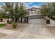 A charming two-story home featuring a spacious driveway and a two-car garage, framed by mature trees at 3241 E Aris Dr, Gilbert, AZ 85298